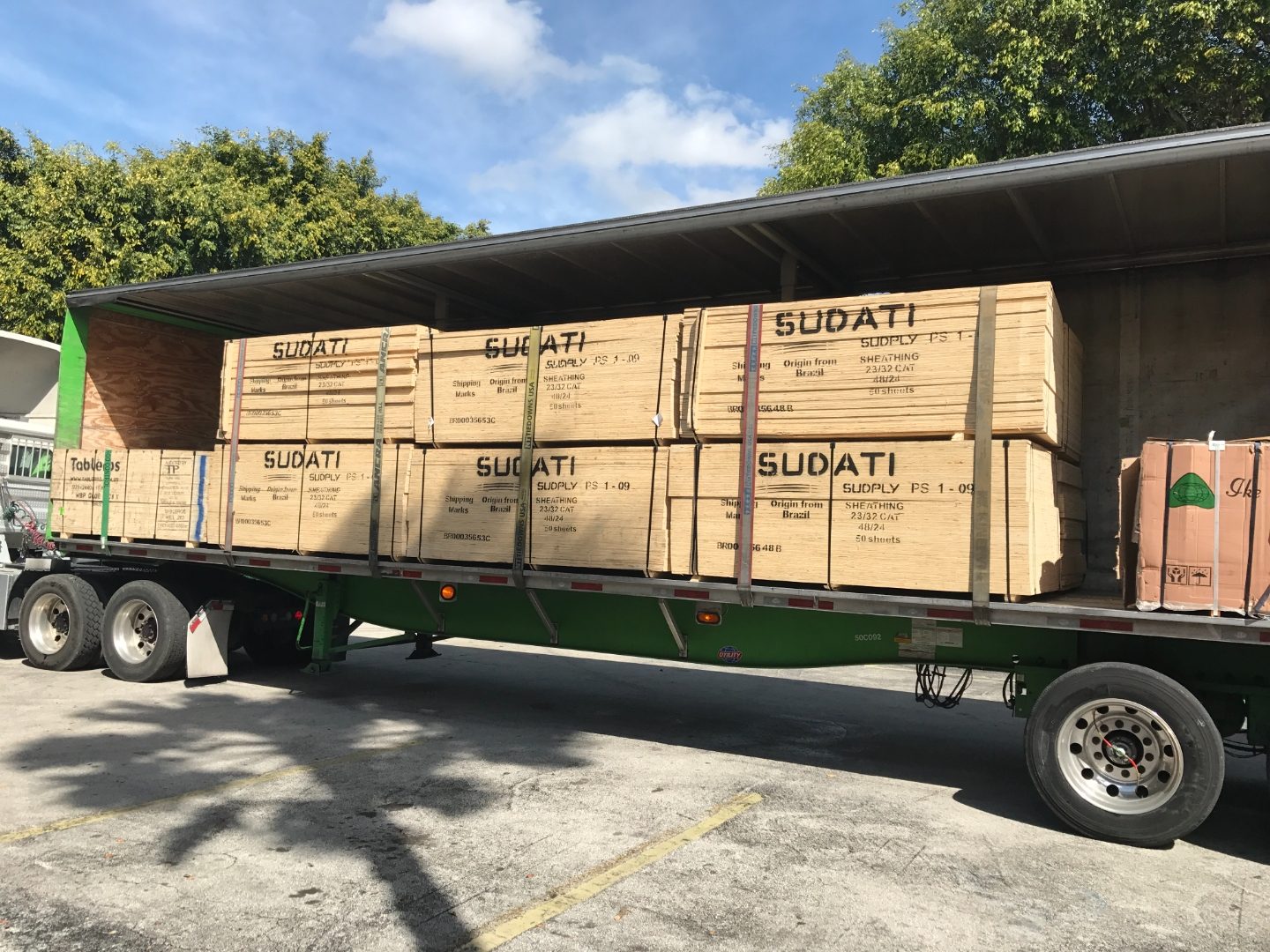 Flatbed truck delivering plywood panels in Miami — same-day delivery from Doral warehouse