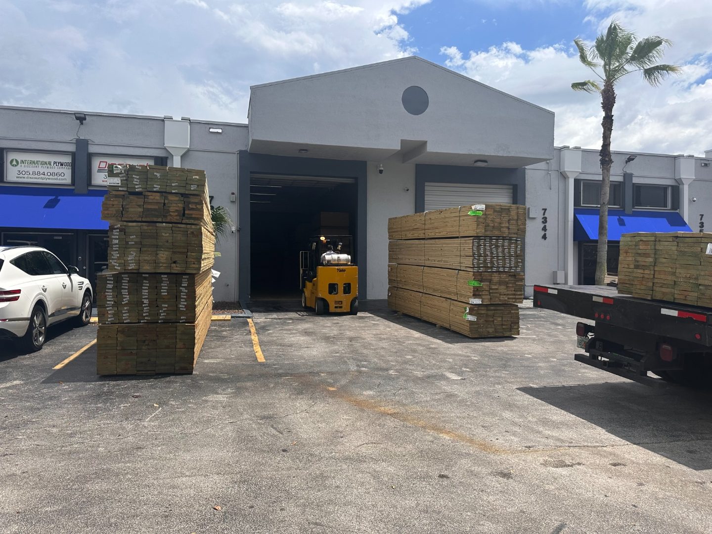 Forklift loading pressure treated lumber at International Plywood warehouse entrance