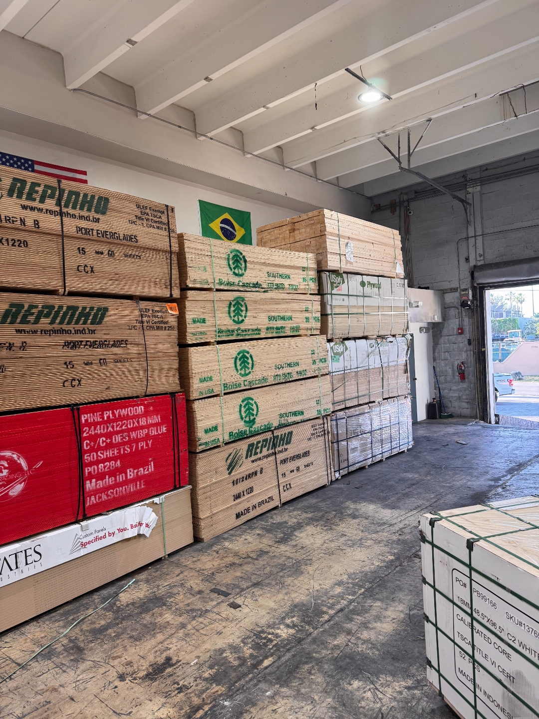 Stacked CDX plywood bundles from Boise Cascade and Repinho inside International Plywood warehouse Doral FL